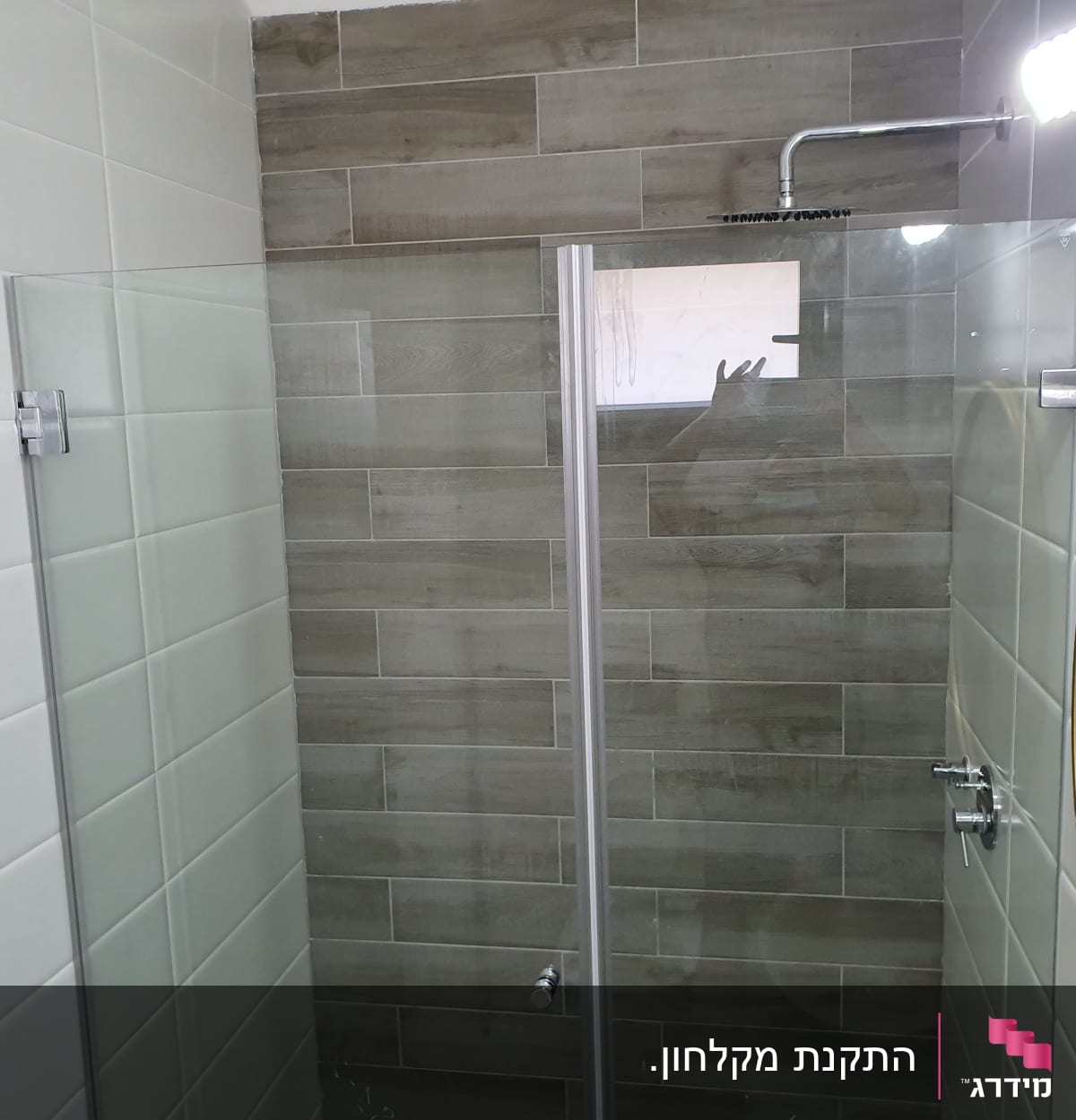 מקלחת עם ראש מקלחת מרובע וקירות אריחים אפורים